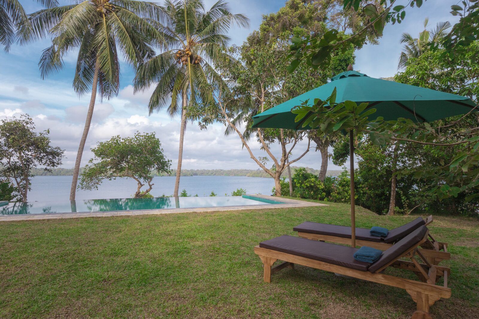 Infinity pool with lounge chairs and lake view at Serendipity Lake